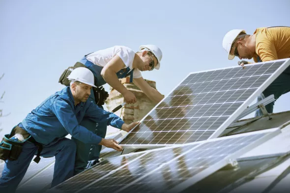 Pracownicy branży OZE instalują panele słoneczne
